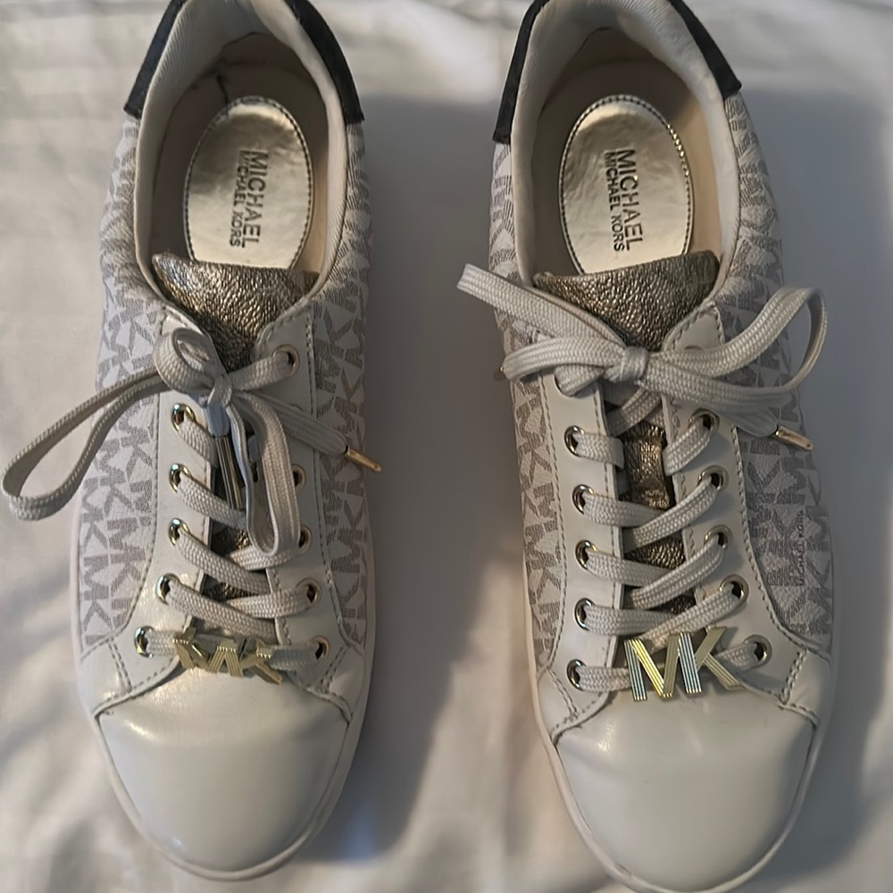 Michael Kors Poppy Sneaker with gold insignia. This sneaker is 7.5. Block logo
